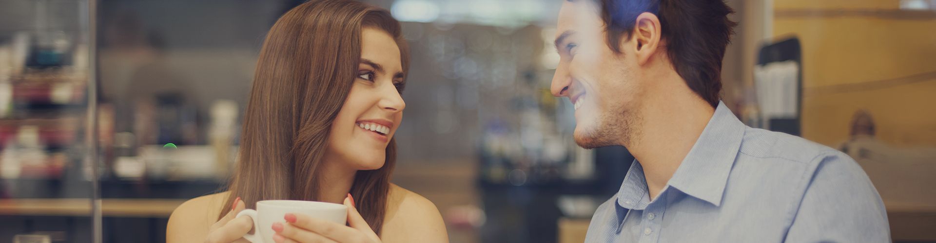 Two people talking across a cafe counter
